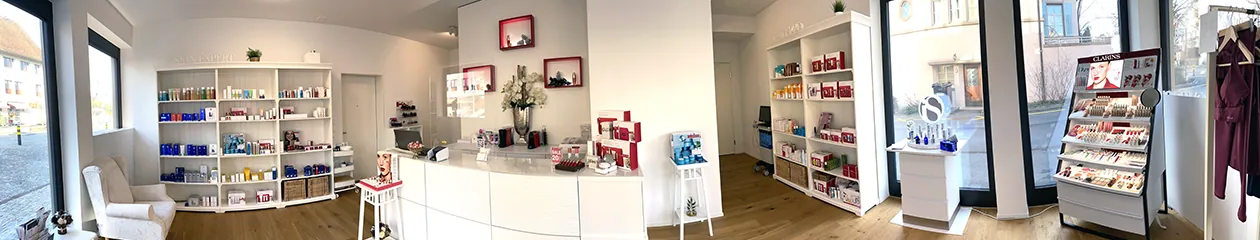 Blick in das helle Kosmetikinstitut mit Empfang und Produktregalen